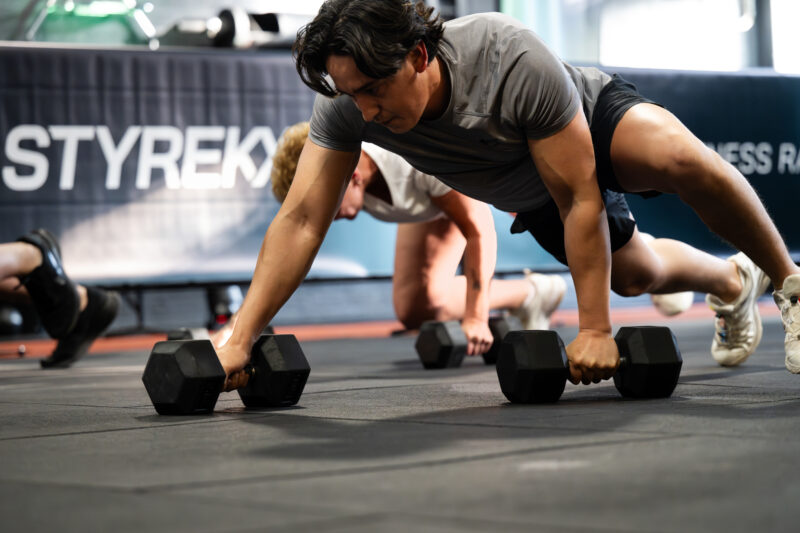 Atleet doet een Load Crawl tijdens STYREKX en focust op kracht en controle tijdens de hybride fitness race.
